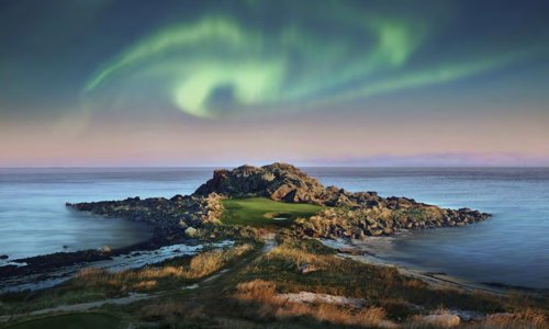 Northern lights over a coastal golf course from the Scandinavia golf itinerary